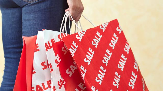 woman carrying shopping bags from sale